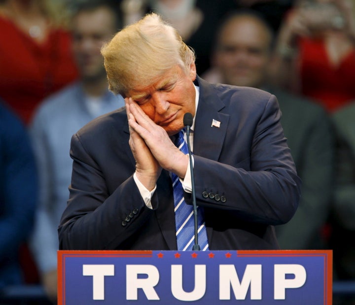 Republican presidential hopeful Donald Trump gestures as if he is sleeping. He was talking about ex-opponent Jeb Bush during a campaign rally in Raleigh, North Carolina on December 4, 2015. 