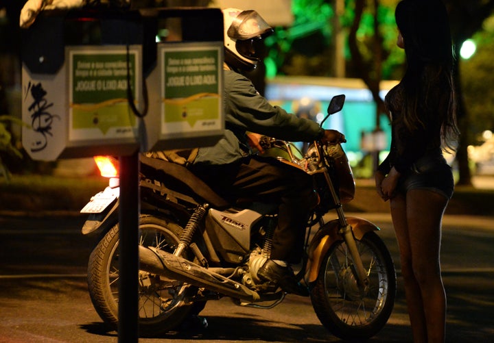 A prostitute talks to a possible client in the streets of Belo Horizonte, Minas Gerais State, Brazil, on April 25, 2013. Sex