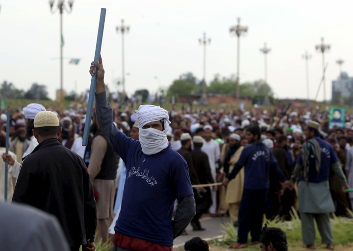 A man holds a stick while taking part in a sit in protest against the execution of Mumtaz Qadri outside the Parliament building in Islamabad, Pakistan, March 29, 2016.