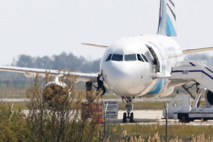 A man tries to leave the plane by climbing out of the cockpit. Conflicting theories emerged about the Egyptian hijacker's mot