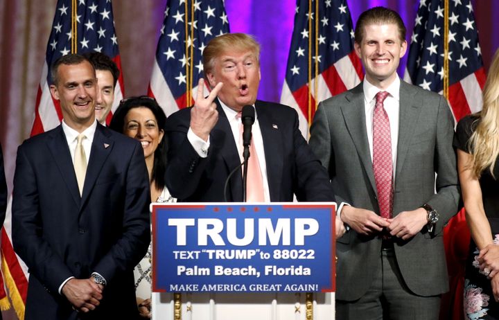 Republican U.S. presidential candidate Donald Trump stands between his campaign manager Corey Lewandowski (L) and his son Eric (R).