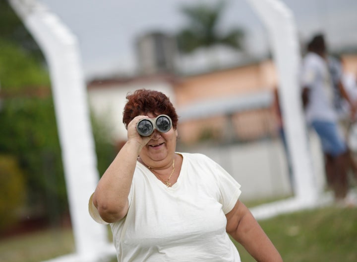 A woman observes Air Force One carrying U.S. President Barack Obama and his family as it comes in to land at Havana's interna