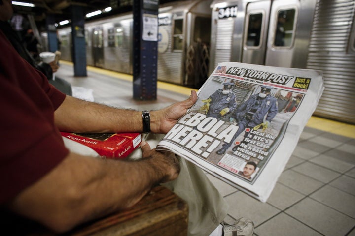 A man shows the front page of a local newspaper while reading in the New York City subway on Oct. 24, 2014. The headline refers to Dr. Craig Spencer, who received treatment for the disease and ultimately recovered.