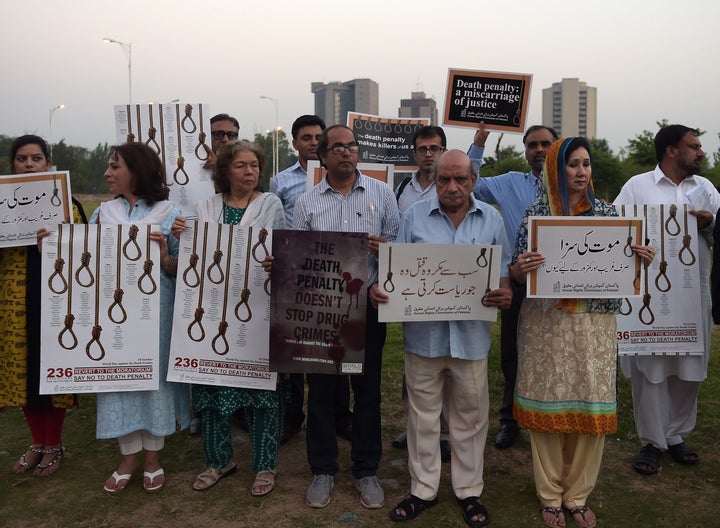 Activists from the Human Rights Commission of Pakistan carry placards during a demonstration to mark International Day Agains