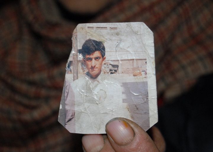 This photograph taken on March 12, 2015, shows one of the Pakistani Kashmir parents of convicted killer Shafqat Hussain holding a photograph of him.
