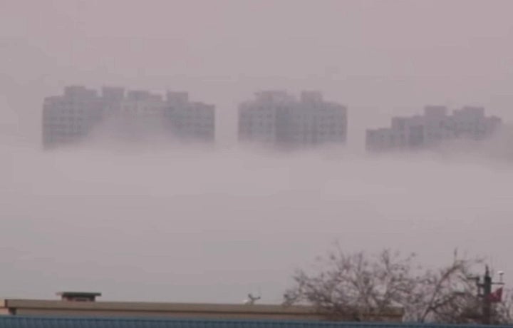 Buildings appear to mysteriously rise above a layer of fog in China's Liaoning Province, prompting speculation as to the cause of this event on March 18, 2016.