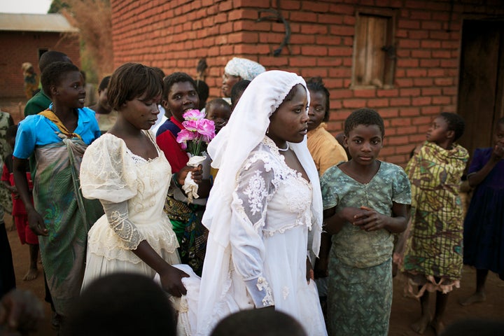 Suzana Nabanda, age 16, walks with her sister after a marriage ceremony in 2006, in a poor village in Malawi. She just got married to a farmer. 