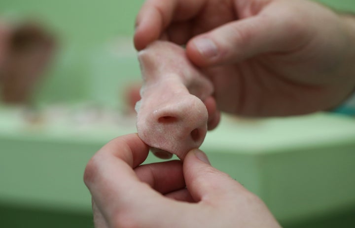 A funeral home in Shanghai is 3D printing body parts for corpses. Above, a visitor holds a 3D printed prosthetic nose during the 3-D Print show at the Business Design Center in London on Friday, Nov. 8, 2013.