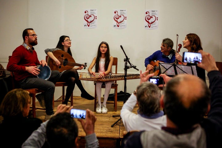 Basel (right), Shaza (center) and Jawa (left) play instruments and sing at the "Syrians Got Talent" concert on Thursday evening in Brussels. They, along with two other Syrian refugees, performed for 200 spectators, many of whom were moved to tears.