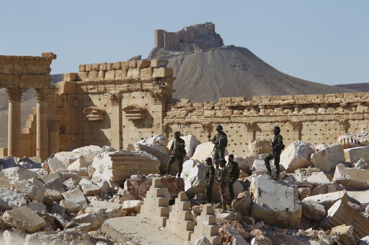 Syrian army soldiers stands on the ruins of the Temple of Bel in the historic city of Palmyra. Syria said some 40 bodies were found in a mass grave in the city after its recapture from ISIS.