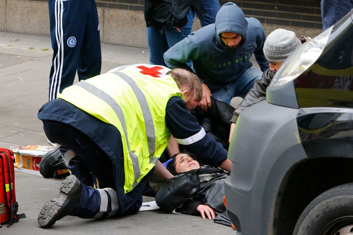 A Muslim woman is attended to by paramedics after being struck by a car that ploughed through a police barricade 