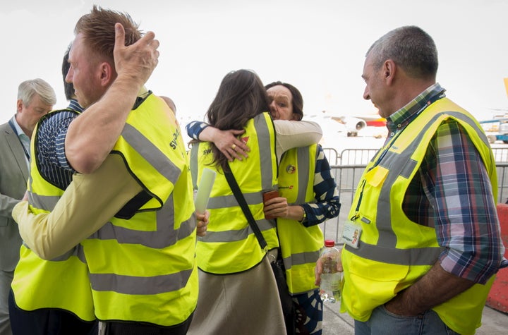 Brussels Airport staff hug as the first plane takes off from Brussels Airport, which partially re-opened following a bomb blast 12 days ago, in Zaventem, Belgium April 3, 2016.