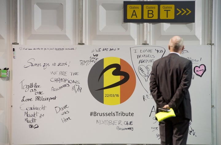 A man looks at a tribute board at Brussels Airport, which partially re-open following a bomb blast 12 days ago, in Zaventem,