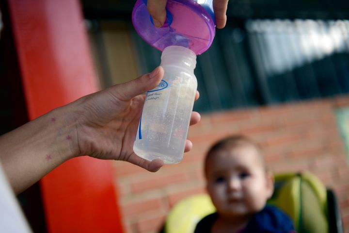 A woman prepares a milk bottle to feed her baby in Caracas on June 18, 2013. The congress would debate about the use of feeding bottle trying to encourage breastfeeding as a way to look after children healt. AFP PHOTO/LEO RAMIREZ (Photo credit should read LEO RAMIREZ/AFP/Getty Images)