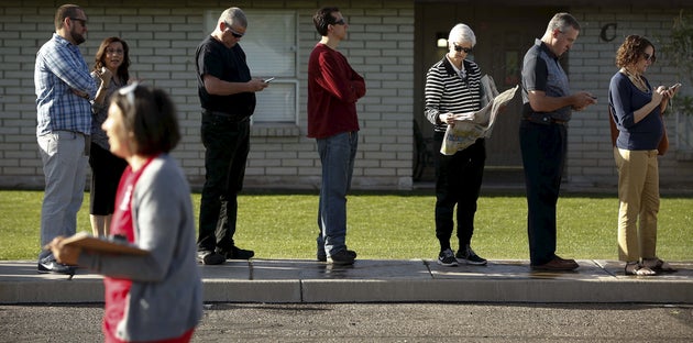 People wait to vote in the U.S. presidential primary outside a polling site in Glendale, Arizona, on...