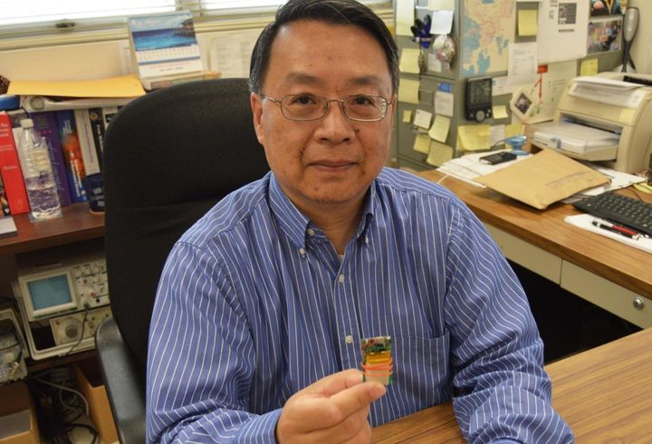 Dr. Yuan Bo Peng holding a chip that's used in the electrical stimulation method.