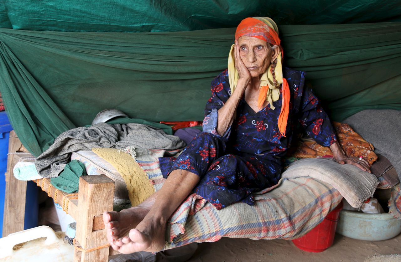 A woman sits inside her hut at the Shawqaba camp. Elderly people with health conditions complain of a lack of medicine, and the high prices when medicine is available.
