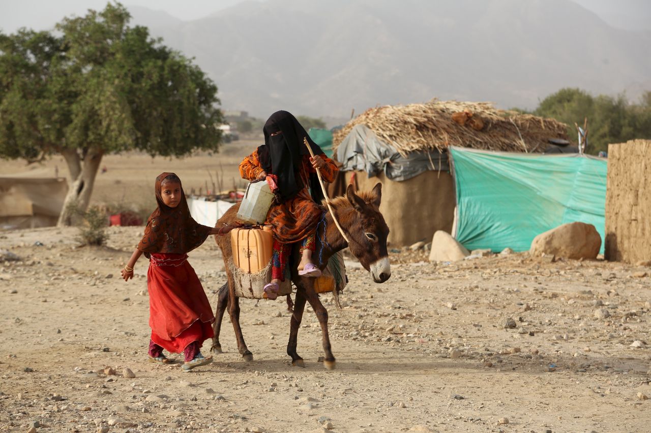 A girl rides a donkey in the camp. Many children suffer from a lack of nutrition and health services in the Shawqaba camp.