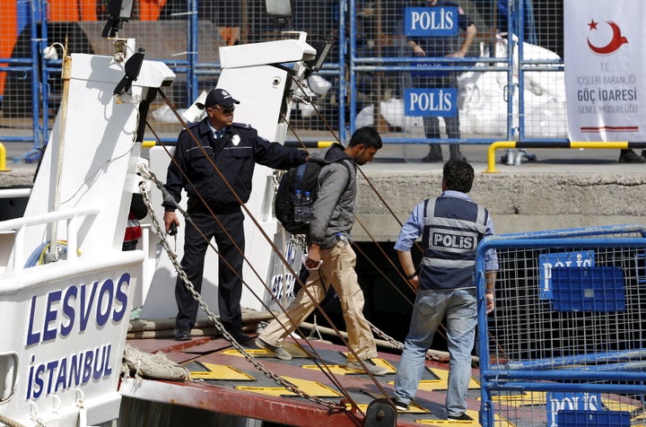 Police escort a migrant ashore in Dikili, Turkey on April 4, 2016. The UNHCR said that Greek police "forgot" to process the asylum claims of some people who were sent back to Turkey from Greece under the EU-Turkey deal. 