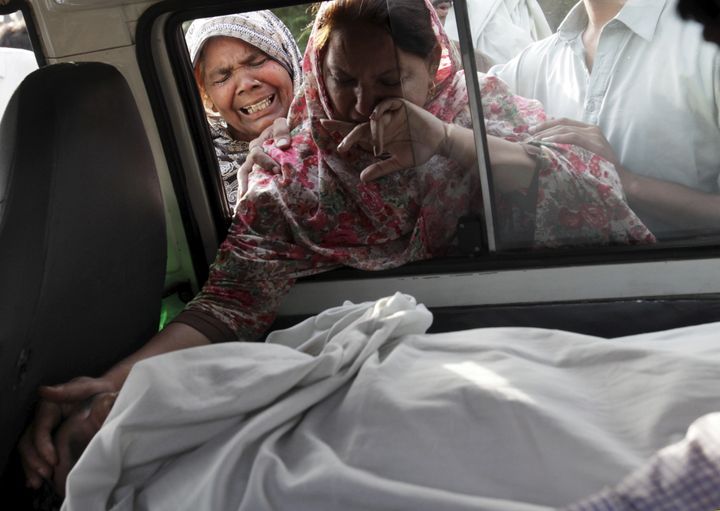 The sister of Aftab Bahadur touches her brother's face following his execution in Lahore, Pakistan, on June 10, 2015. Bahadur was 15 when he was sentenced to death for murder.
