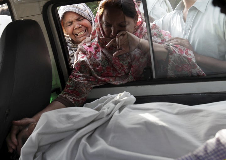 The sister of Aftab Bahadur touches her brother's face following his execution in Lahore, Pakistan, on June 10, 2015. Bahadur