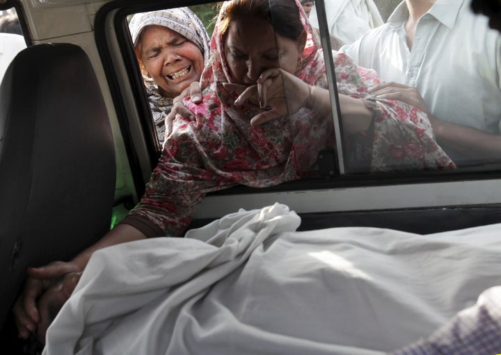 The sister of Aftab Bahadur touches her brother's face following his execution in Lahore, Pakistan, on June 10, 2015. Bahadur was 15 when he was sentenced to death for murder.