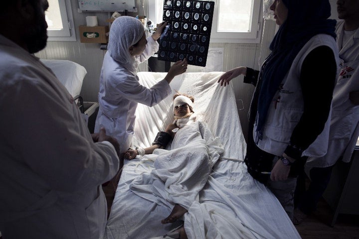 The hospital was often engaged in a flurry of activity. Doctors examine a head trauma patient at the ICU in Kunduz in Sept. 2013.