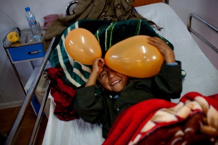 An eight-year-old boy who broke his leg plays in his hospital bed in the in-patient ward.