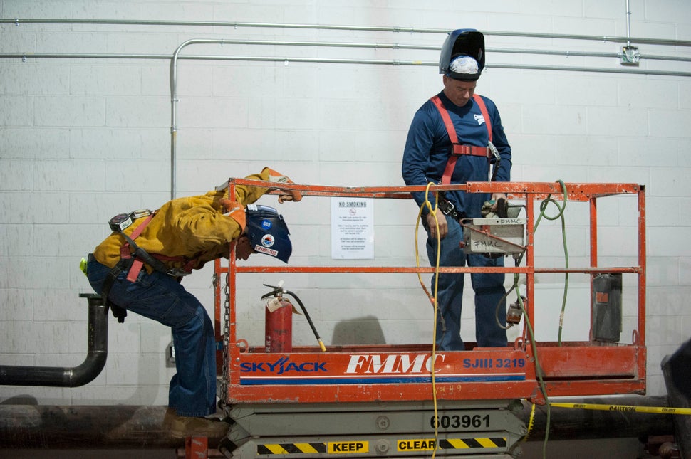 Ferreira climbs onto a platform with his prosthetic legs at work. 