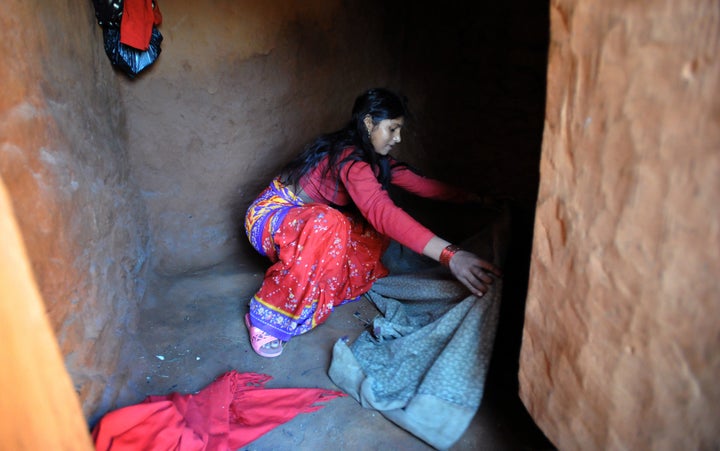 Nepalese villager Chandrakal Nepali prepares her bedding inside a 'chhaupadi house.' Isolation is part of a centuries-old Hin