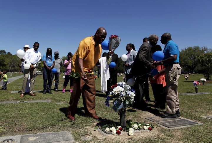 Gary Butts, family friend of the late Walter Scott, lays a rose at the gravesite as relatives and friends gathered to remember Scott.