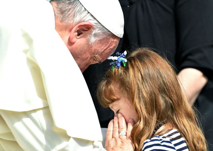 Pope Francis blesses the eyes of Lizzy Myers, a 5-year-old American girl who will likely lose her vision due to a rare condition.