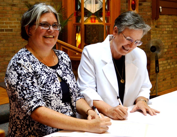 Sister Jennifer Wilson (left) signs her final vows.