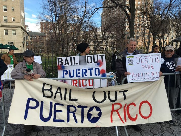 Activists protest at a Federal Reserve event in Manhattan, asking for relief for Puerto Rico's debt.