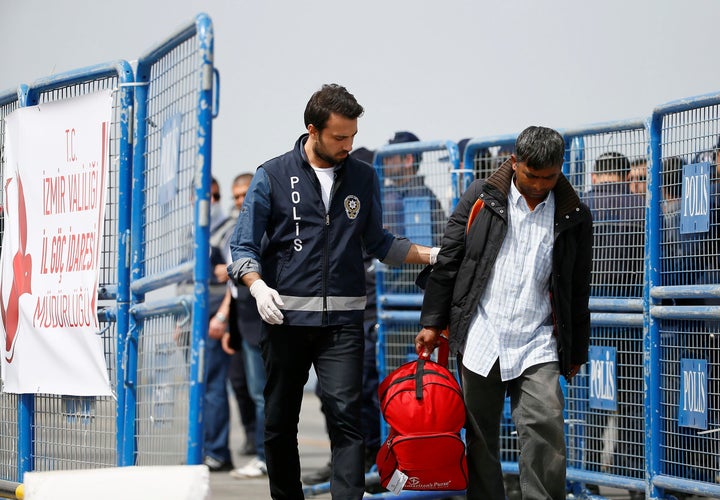 More than 120 migrants and refugees were returned to Turkey from the Greek island of Lesbos on Friday. Police escort a migrant in the city of Izmir, Turkey.