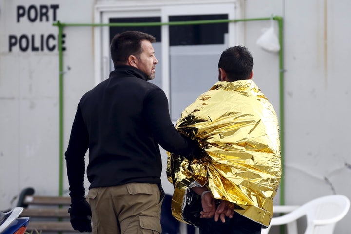 At least two rights activists plunged into the water in Greece, in an attempt to prevent the vessel from sailing toward Turkey. In this photo, one of those activists is detained by a Greek Coast Guard officer.