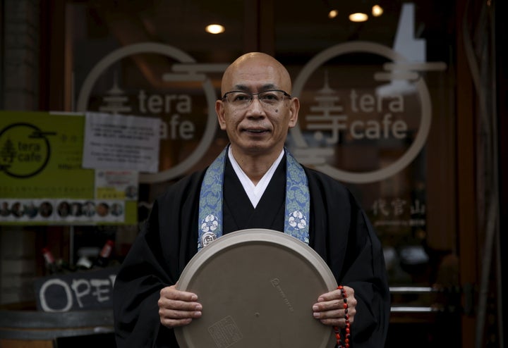 Shokyo Miura, a Buddhist monk and one of the on-site priests, poses for pictures outside Tera Cafe in Tokyo, Japan, April 1, 2016.