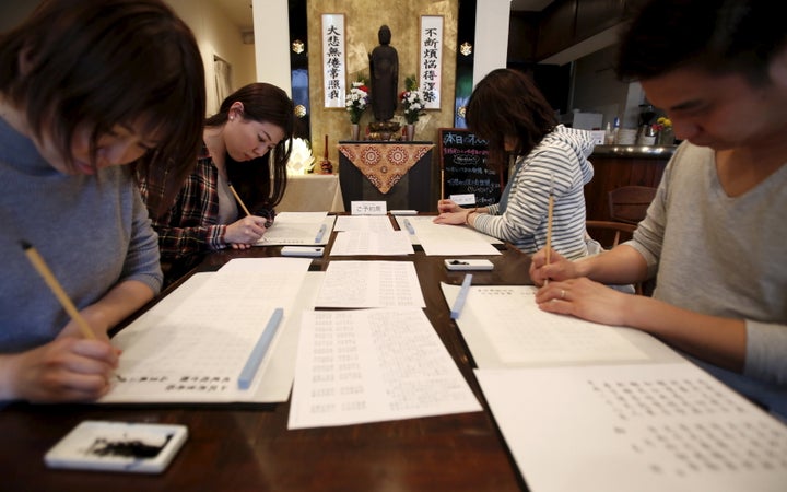 People trace Buddhist sutras with brushes at Tera Cafe in Tokyo, Japan, April 1, 2016.