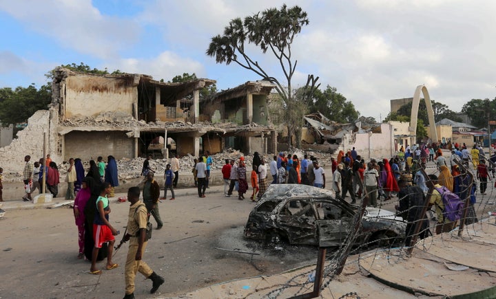 Residents view the damage after a car bombing at a hotel in Mogadishu in February 2016. Al Shabab has stepped up attacks