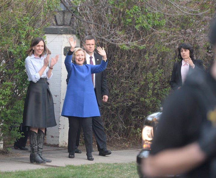 Hillary Clinton waves to neighbors as she leaves a fundraising party at Colorado Governor John Hickenlooper's home.