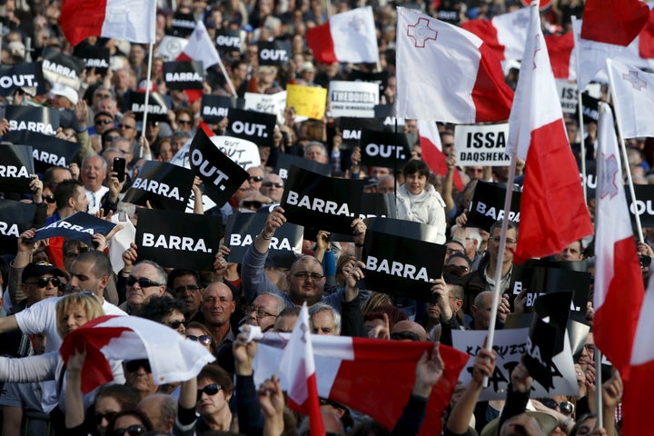 Protestors hold posters reading "Out" during a demonstration calling on Maltese Prime Minister Joseph Muscat to resign after two members of his government were named in the Panama Papers leak scandal.