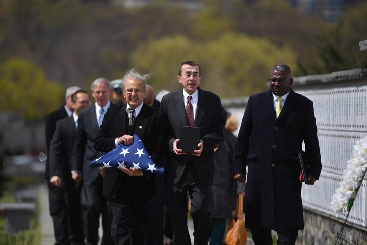 Nick Addams, left, and Bill Sheppard, center, rallied their neighbors together to pay for Andrew Moore's memorial service at Arlington National Cemetery on Friday.
