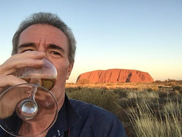 Michael Pattemore enjoys a glass of wine at Ayres Rock in Australia.