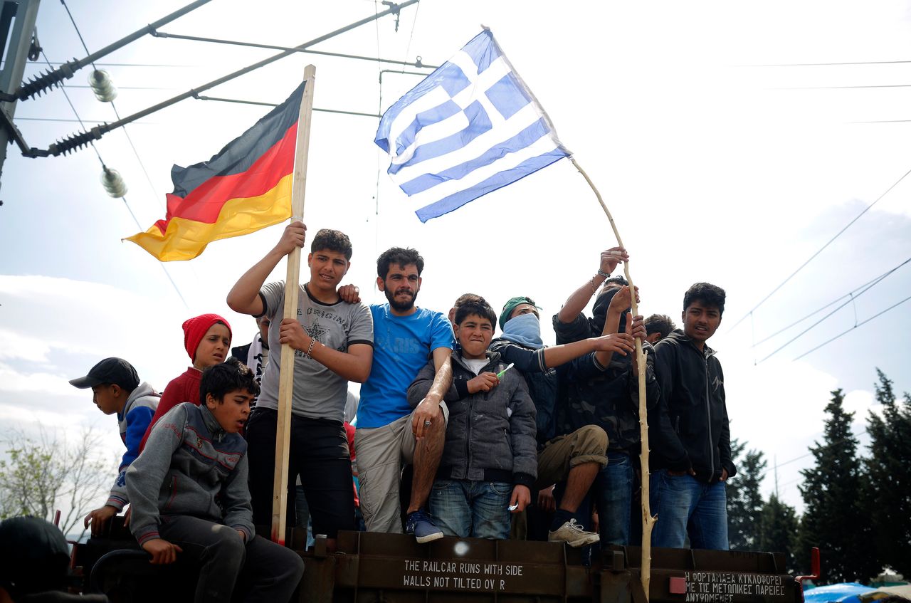 As Greece begins to deport people back to Turkey, reports of increased arrivals to Europe through the other routes are simultaneously resurfacing. People wave German and Greek flags at the Greece-Macedonia border.