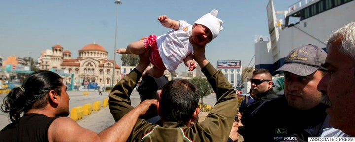 Photographers and journalists in Greece encountered an angry Afghan man lifting a baby over his head last week. Photos of the incident have sparked outrage.