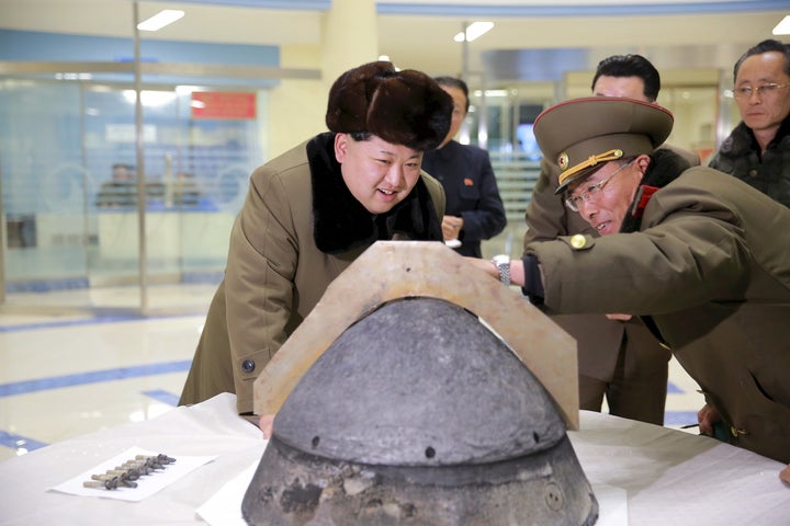North Korean leader Kim Jong Un looks at a rocket warhead tip after a simulated test of atmospheric re-entry of a ballistic m