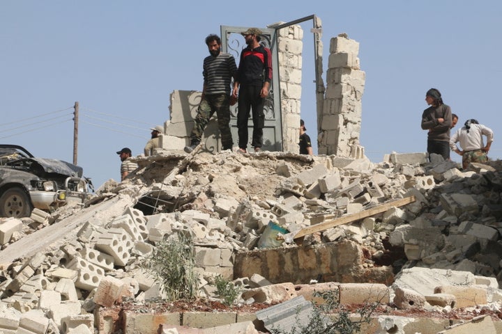 The Syrian conflict has killed over 250,000 and created millions of refugees. Men inspect damage after an airstrike in the opposition-held town of Turmanin, Syria.