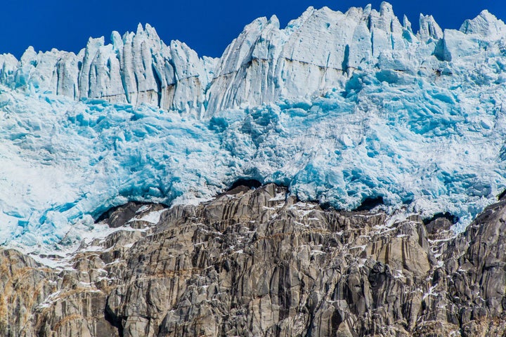 Massive walls of ice tower above a rock cliff on the edge of the Harding icefield. The couple reportedly hired a private plan