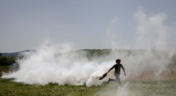Macedonian police fired tear gas Wednesday after about 50 people tried to pull down the razor wire fence separating