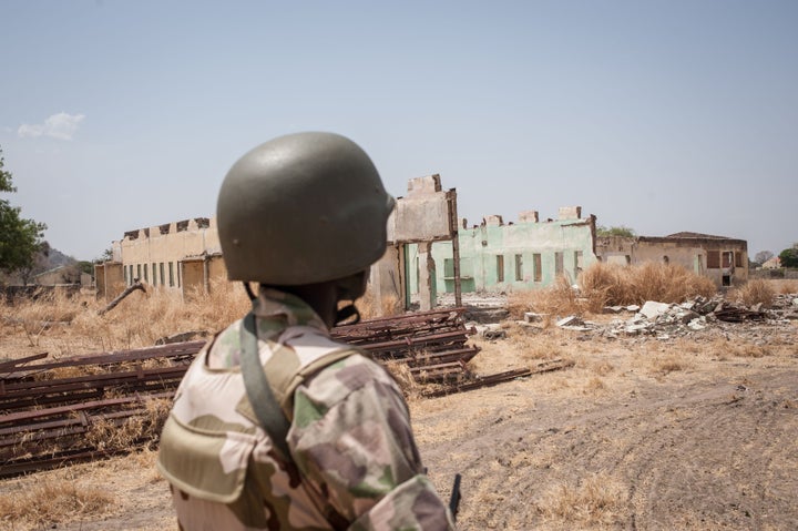 A Nigerian soldier looks at the remains of the Chibok school, where the girls were captured, still in ruins this March. The government is reportedly in talks to free the girls, but two years later there is still no sign of them.